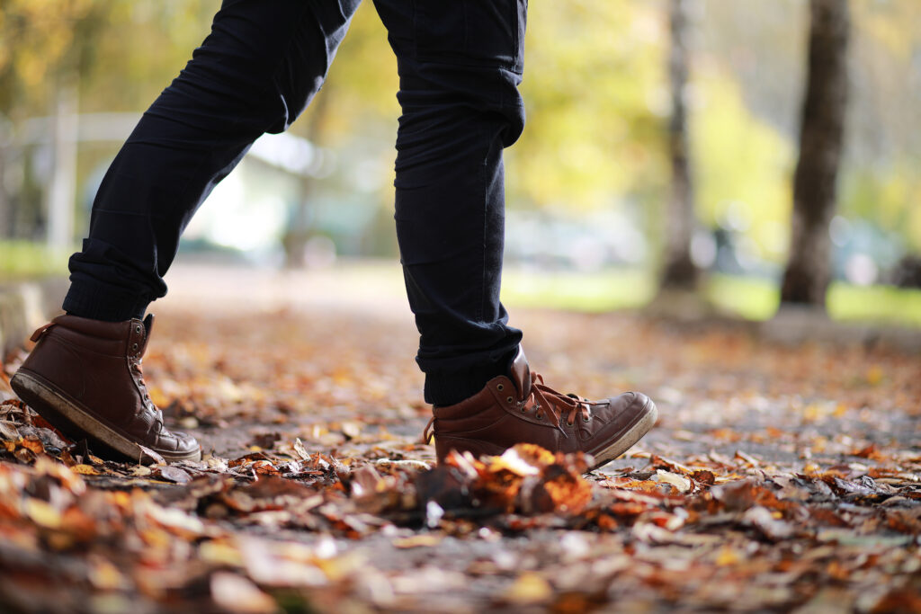 Autumn,Park,Man,Walking,Along,A,Path,Foliage