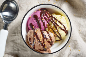 bowl of various ice cream decorated with chocolate sauce, top view