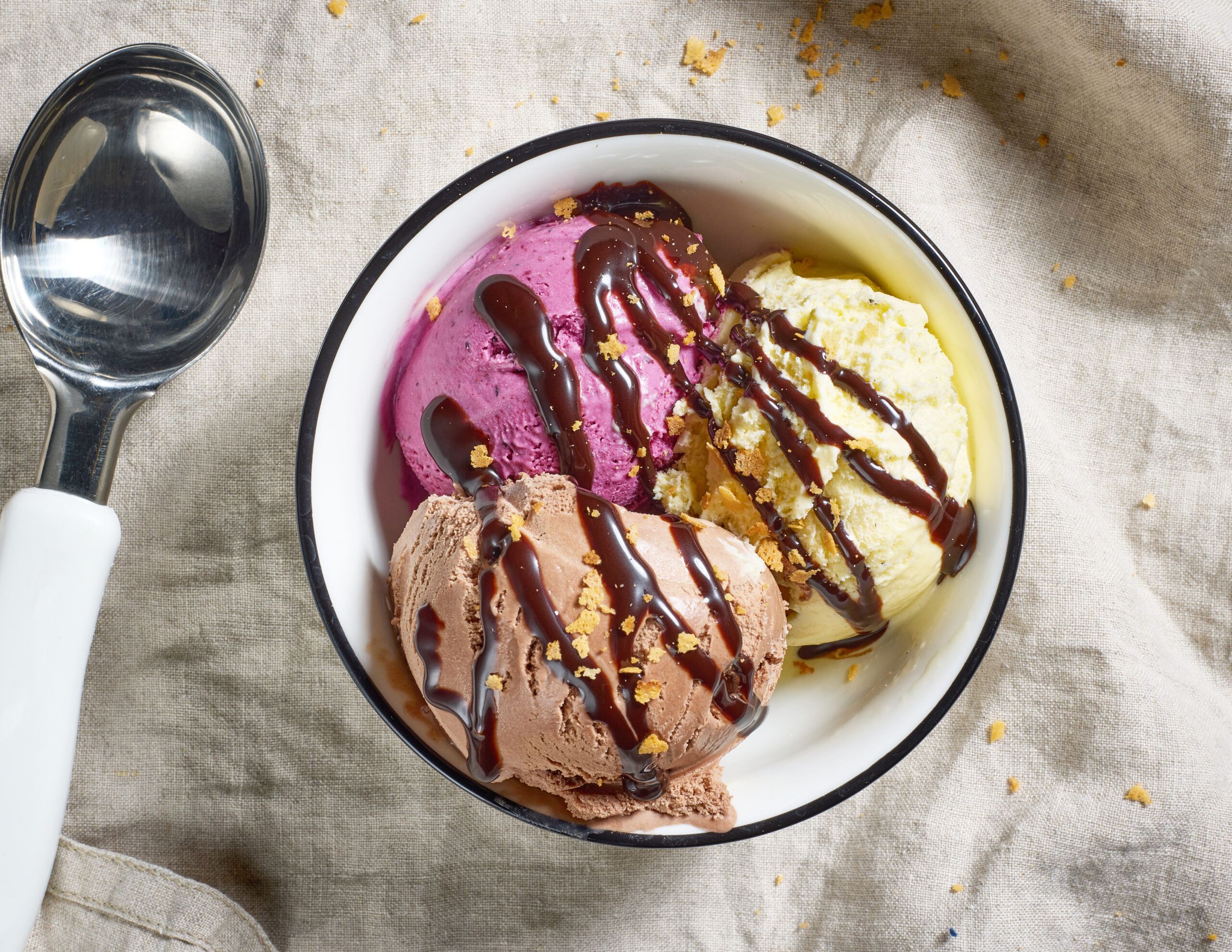 bowl of various ice cream decorated with chocolate sauce, top view